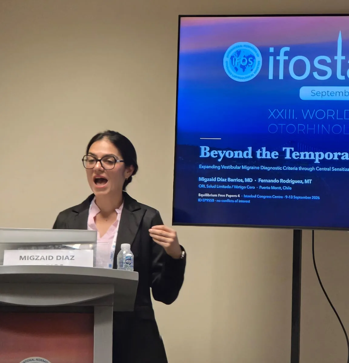 La Dra. Migzaid Díaz expone en el podio del Mundial IFOS de Estambul; en la pantalla, su trabajo «Beyond the Temporal Threshold».