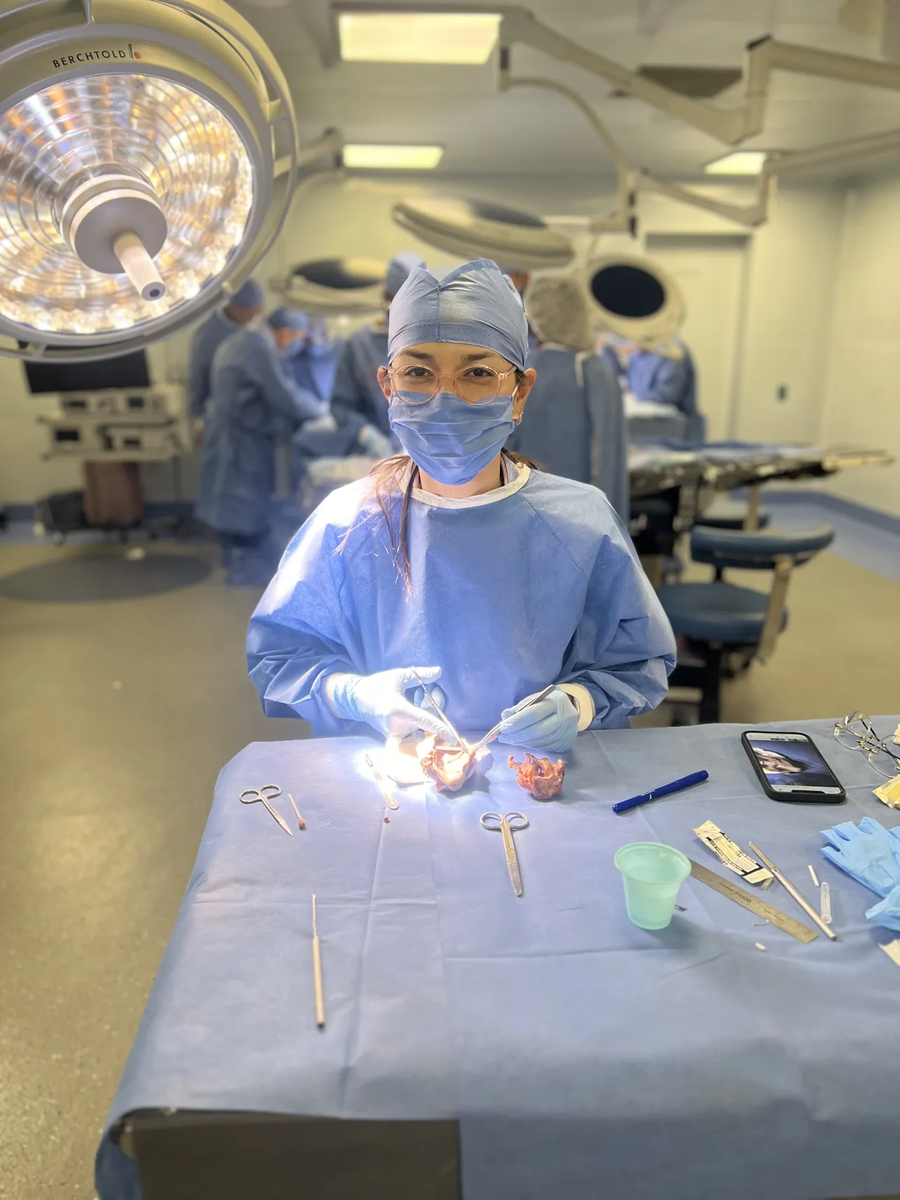 La Dra. Migzaid Díaz, con gorro y mascarilla, practica microcirugía en un quirófano de entrenamiento.